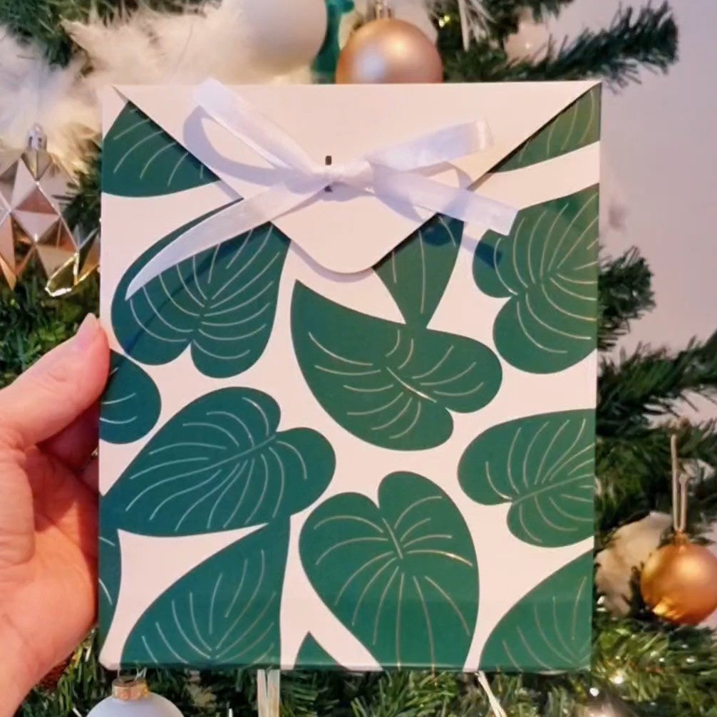 Cadeauverpakking met groene bladerenprint en witte strik, voor kerstboom, Maak Atelier